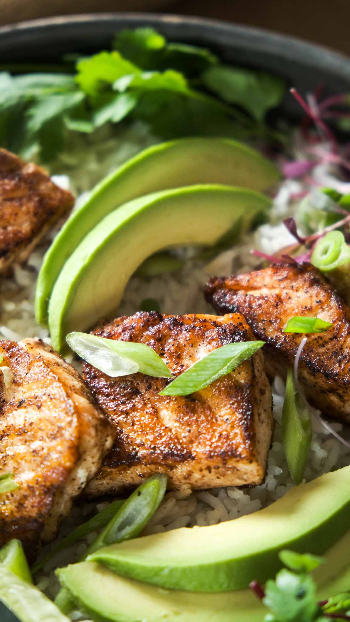 up close picture of seared spicy salmon and avocado slices